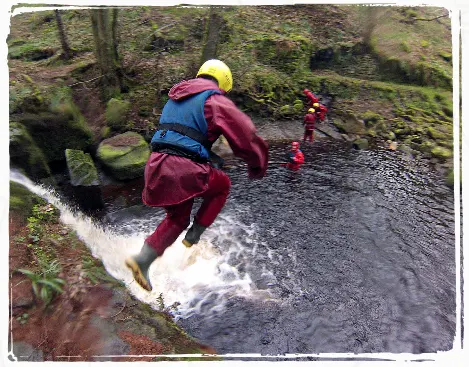 river-scrambling person jumping into a natural plunge pool